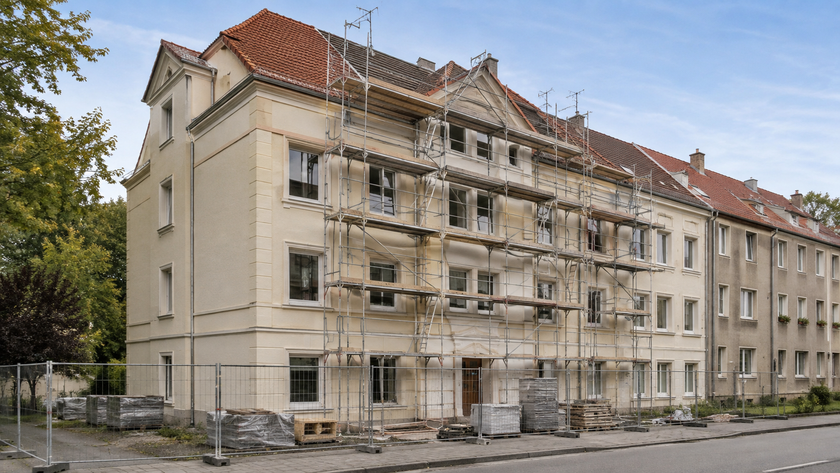 Sanierungsbaustelle an einem Mehrfamilienhaus mit Gerüst und gesicherter Baustelle